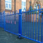 A blue steel commercial gate on a school yard in Birmingham.