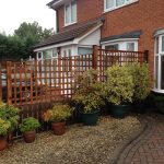A fence dividing two houses in Birmingham. The fence has t type timber trellis fencing panels.
